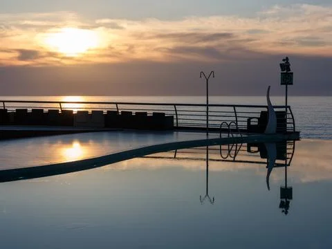 Golden Sunset Reflection in Luxury Infinity Pool. Stock Photos