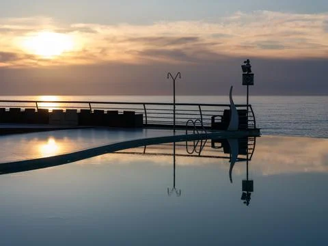 Golden Sunset Reflection in Luxury Infinity Pool. Stock Photos