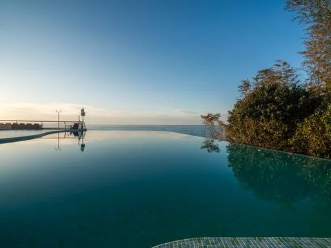 Golden Sunset Reflection in Luxury Infinity Pool. Stock Photos