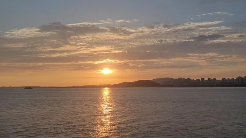Golden Sunset Reflection over Ocean with Coastal City Skyline, 4K Vídeos de archivo 330166354