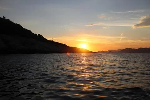 Golden sunset reflection path on Adriatic Sea near rocky coast in Croatia 写真素材