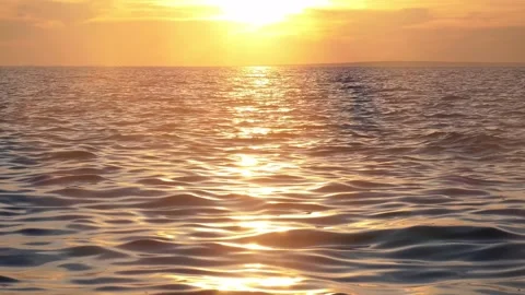 Golden Sunset Reflection on Shimmering Ocean Waves with Bright Sun Flare Stock Footage 331899825