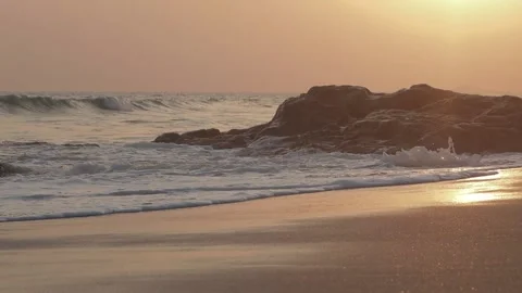 Golden Sunset on sandy beach waves hitting against rocks Stock Footage 306248512