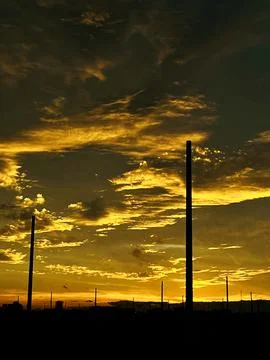 Golden Sunset Silhouette with Dramatic Cloudscape and City Poles Stock-Fotos
