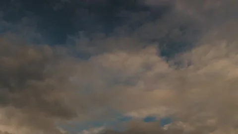 Golden sunset sky with brooding clouds. Warm light contrasts with heavy cloud Stock Footage 323437340