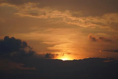 Golden sunset sky with dramatic clouds over the horizon at dusk Stock Photos