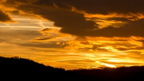 Golden sunset timelapse with moving clouds and black forest silhouette Stock Footage 123116905