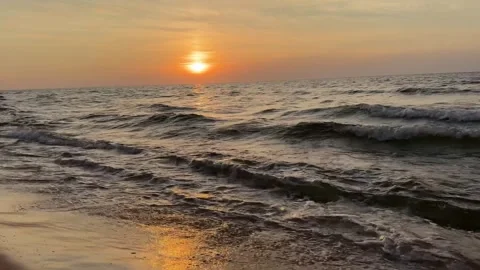 Golden sunset waves gently rolling onto the shore Stock Footage 314796823