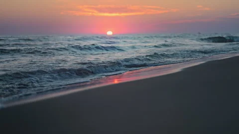 Golden sunset waves rolling gently on sandy beach in 4K slow motion Stock Footage 318103399