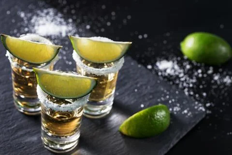 Golden tequila on black background Stock Photos