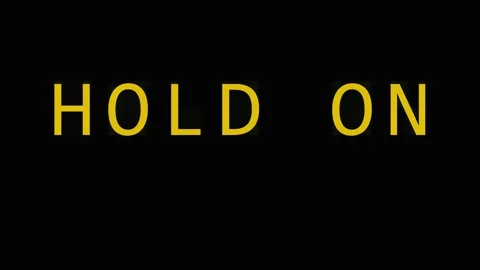 Golden text HOLD ON repeating across black background with subtle cinematic.. Stock Footage 343407911