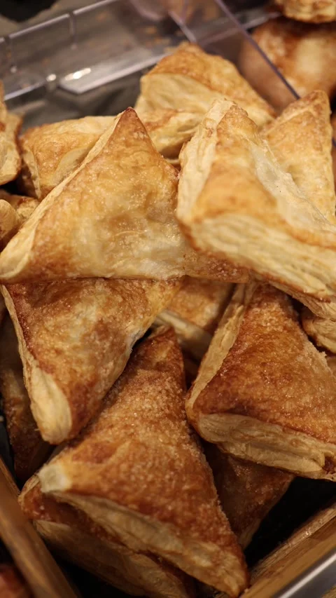 Golden triangular puff pastries with flaky layers and sugar topping in bakery Stock Footage 345356994