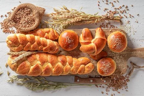 Golden variety of breads on table in rustic kitchen. Stock Photos