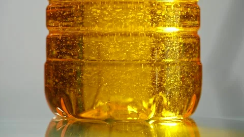 Golden vegetable oil texture inside plastic bottle macro Stock Footage 335154909