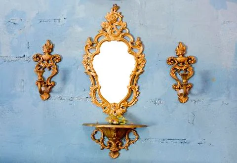 Golden vintage mirror with gold candlestick on wall Stock Photos