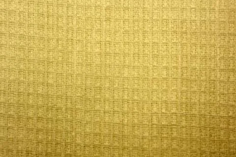 Golden waffle background with regular grid pattern . Stock Photos