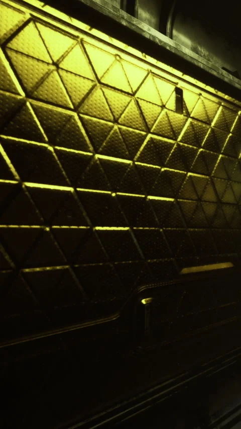 Golden wall with textured pattern and light reflections in a dark space Stock Footage 334171658