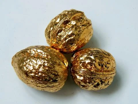 Golden walnuts on a light background Stock Photos