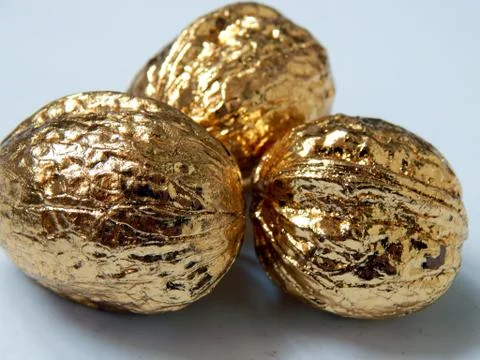 Golden walnuts on a light background Stock Photos
