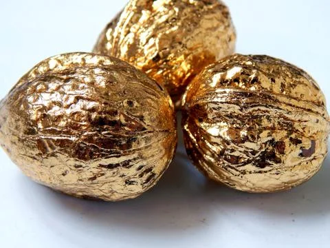 Golden walnuts on a light background Stock Photos