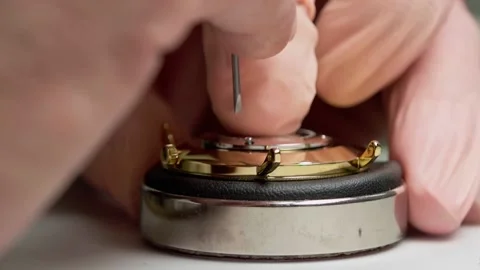 Golden watch being assembled - Back is being screwed onto the watch body. Stock Footage 167573495