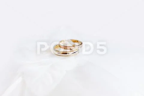 Golden wedding rings with diamonds on silk fabric. Romantic symbol of love an Stock Photos