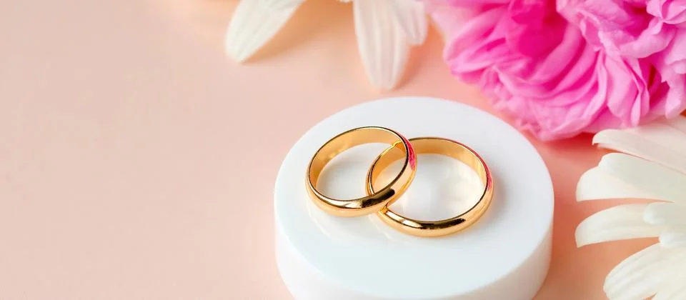 Golden wedding rings representing commitment and lasting love, placed on a .. Foto stock