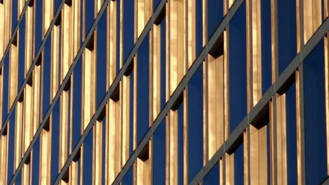 Golden window frames on a high office building, with blue sky reflection in Stock Footage 231993981