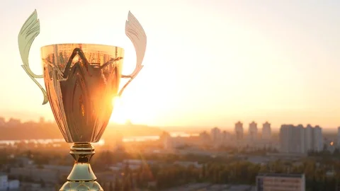 Golden winnet trophy cup on a big city gold sunset background Stock Footage 77074490