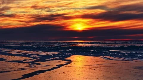 Golden winter sunset reflecting on a beautiful frozen beach and arctic ocean Stock Footage 346594596