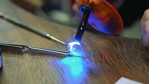 Goldsmith makes the drying of the enamel layer using an ultraviolet device on Stock Footage 73608035
