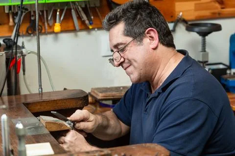 Goldsmith sands a silver ring on the workbench. Stock Photos