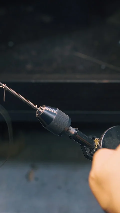 Goldsmith turns handle of coiling tool with wire close view Stock Footage 317089587