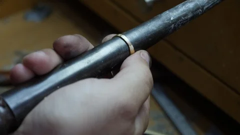A goldsmith uses a ring mandrel to resize a gold ring Vidéo 112446197