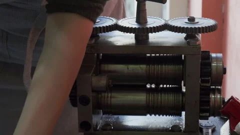 Goldsmith using a press to roll silver ring blank. Close up. Jewelry handicraft Stock Footage 263836323