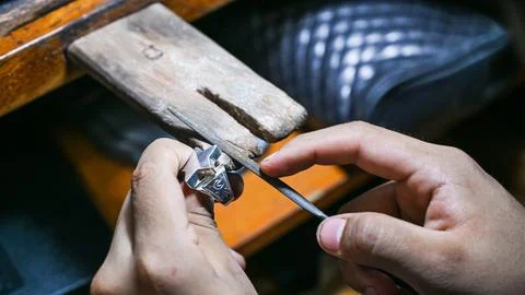 Goldsmith working on a silver ring with a file Stock Photos