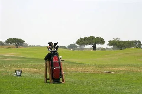 Golf Bag Golf Bag with a basket of golfballs and a driving range in the ba... Stock Photos