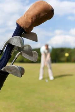 Golf bag with golfer in background Photos
