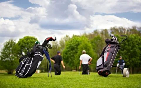 Golf bags with group of players Stock Photos