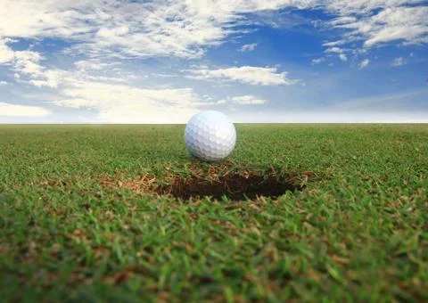 Golf ball about to fall into the cup Stock-Fotos
