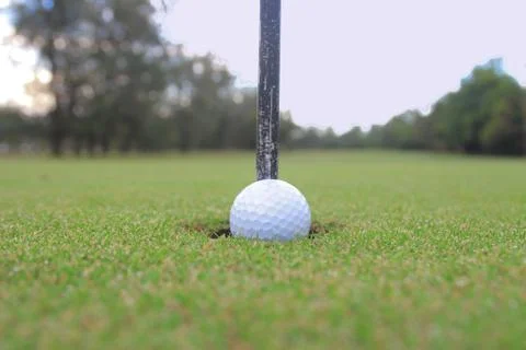 Golf ball about to fall into the cup Stock Photos