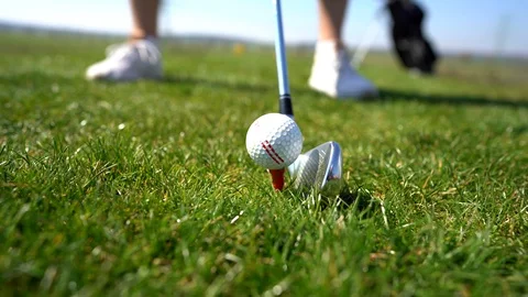 Golf ball and clubs close to it during game on green lawn on spring weekend Stock Footage 128131653