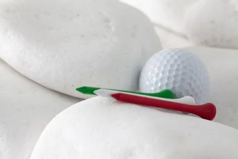 Golf ball and tees between white stones 库存照片