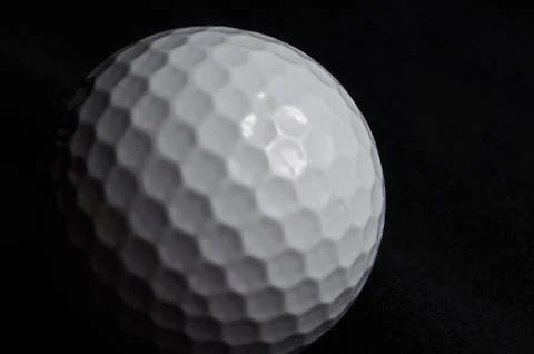 Golf ball on black background Stock Photos