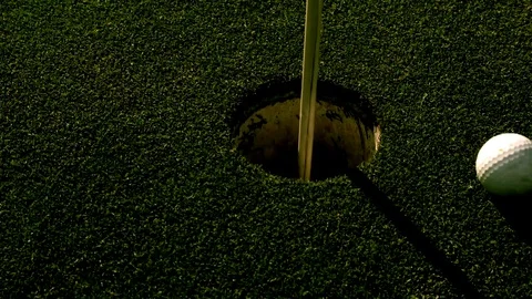 Golf ball entering a hole  Stock Footage