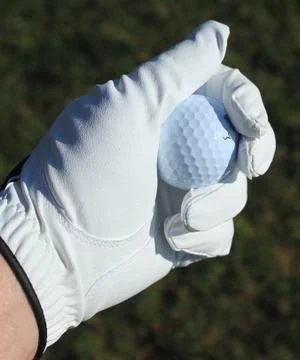 Golf ball in gloved hand Stock Photos