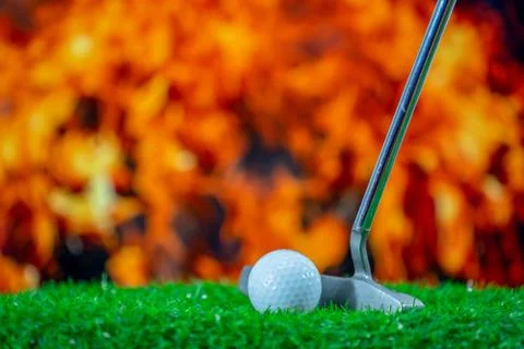 Golf ball on grass for golfer hitting on fire flame background Stock Photos