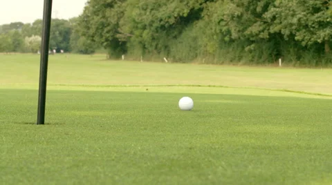 Golf ball lands close to the flag/hole - Slow Motion Stock Footage