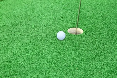 Golf ball on lip of cup 스톡 사진