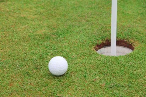 Golf ball on lip of cup 写真素材